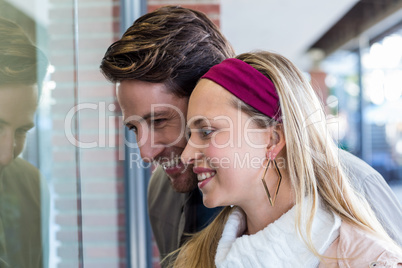 Smiling couple going window shopping