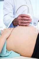 Midsection of doctor performing ultrasound on woman