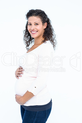 Portrait of happy pregnant woman holding abdomen