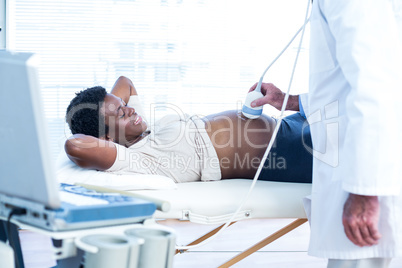 Male doctor applying applying gel on belly