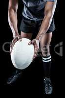 Low section of athlete holding rugby ball