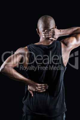 Rear view of muscular man suffering from backache