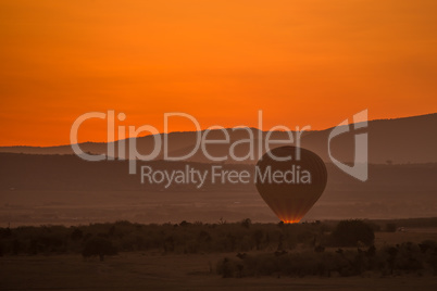Balloon glowing in orange light before dawn