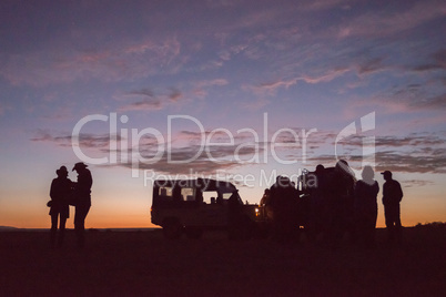 Silhouettes of people with trucks at sunrise