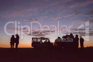 Silhouettes of people with trucks at sunrise