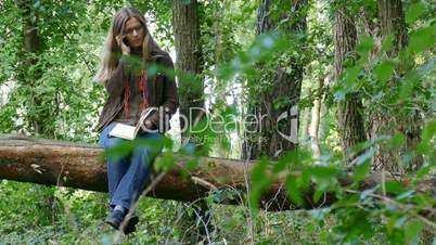 a woman sitting on a fallen tree
