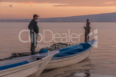 Man brushing teeth on jetty at dawn