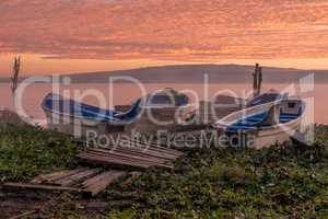 Four boats moored by dock at dawn