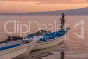 Two boats moored by jetty at dawn