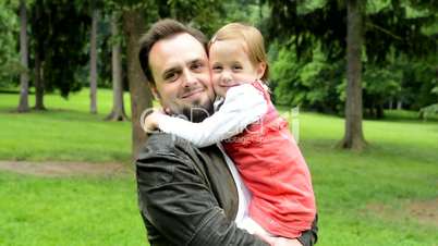 handsome dad with cute daughter smile to camera - park