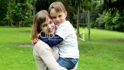 pretty mother with little son smile to camera - park