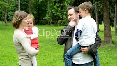 family (middle couple in love, cute girl and small boy) together talk in the park