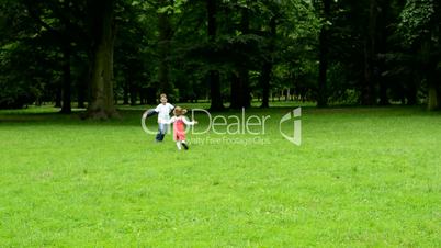 children (siblings - boy and girl) playing in the park - siblings embrace and running away - park