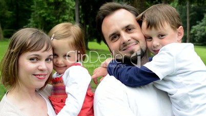 family (middle couple in love, cute girl and small boy) smile to camera in the park