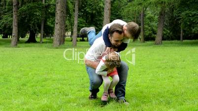 middle aged father plays with children (boy and girl) - park