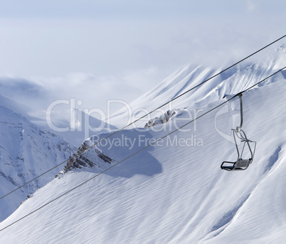 Chair lift and mountains in fog