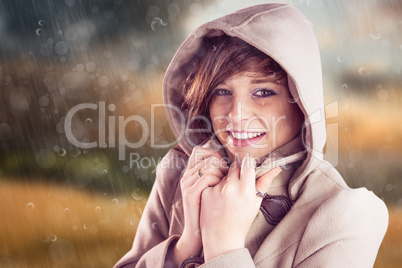 Composite image of portrait of smiling woman wearing winter coat