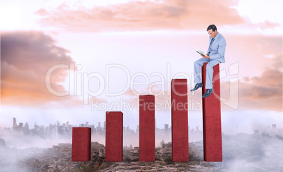 Composite image of businessman reading book while sitting over w