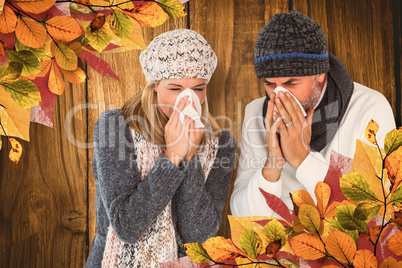 Composite image of couple sneezing in tissue