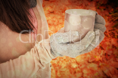 Composite image of woman holding polka dotted mug