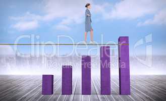 Composite image of businesswoman walking tightrope