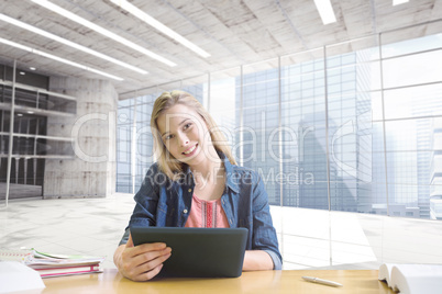 Composite image of student studying in the library with tablet