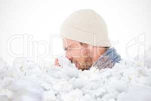 Composite image of handsome man in winter fashion blowing his no