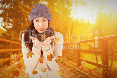 Composite image of beautiful brunette smiling at camera and blow