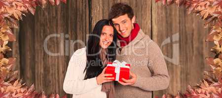 Composite image of young couple holding a gift