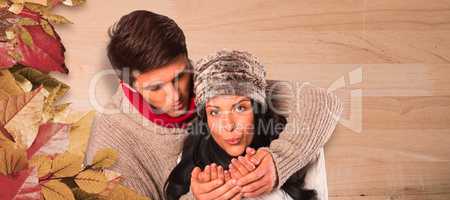 Composite image of young couple blowing over hands