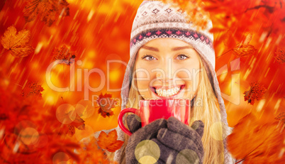 Composite image of happy blonde in winter clothes holding mug