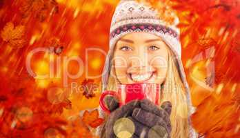 Composite image of happy blonde in winter clothes holding mug