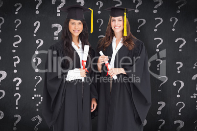 Composite image of full length shot of two women graduating