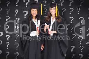 Composite image of full length shot of two women graduating