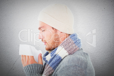 Composite image of handsome man in winter fashion blowing his no