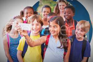 Composite image of cute pupils using mobile phone