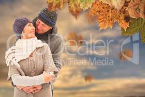 Composite image of happy mature couple in winter clothes embraci