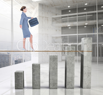 Composite image of businesswoman walking tightrope