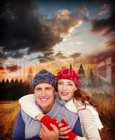 Composite image of happy couple in warm clothing