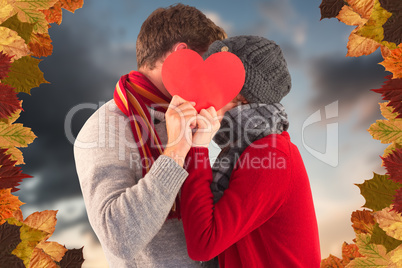 Composite image of couple holding a red heart