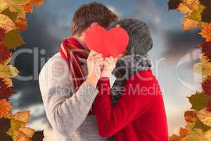 Composite image of couple holding a red heart