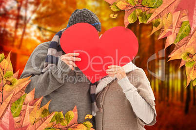 Composite image of happy mature couple in winter clothes holding