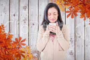 Composite image of smiling woman smelling hot beverage