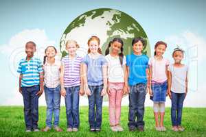 Composite image of cute pupils smiling at camera in classroom