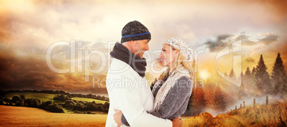 Composite image of happy husband holding wife while looking at e