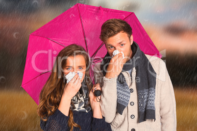 Composite image of couple blowing nose while holding umbrella