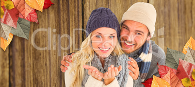 Composite image of attractive couple in winter fashion smiling a