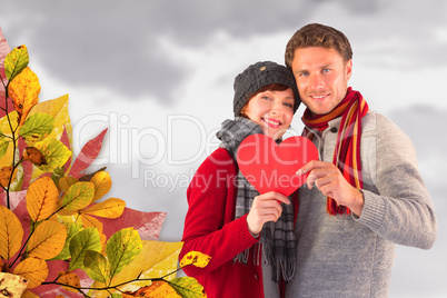 Composite image of couple holding a red heart