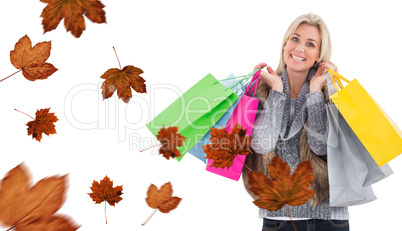 Composite image of blonde in winter clothes holding shopping bag