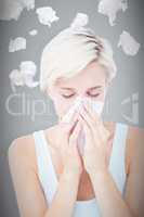 Composite image of sick woman blowing her nose